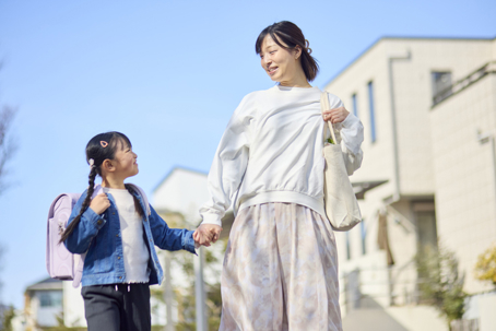 mother and daughter holding hands on the way to school