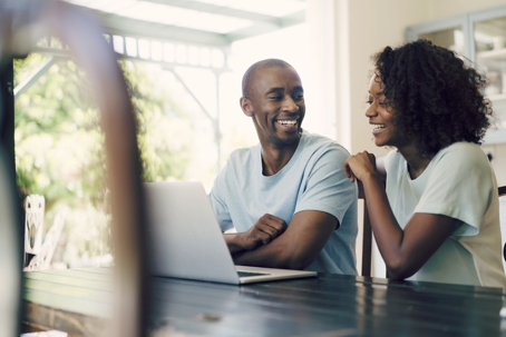 happy couple looking at laptop